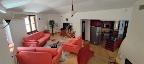 Living room with red leather sofas and an open kitchen in the background. - image 8