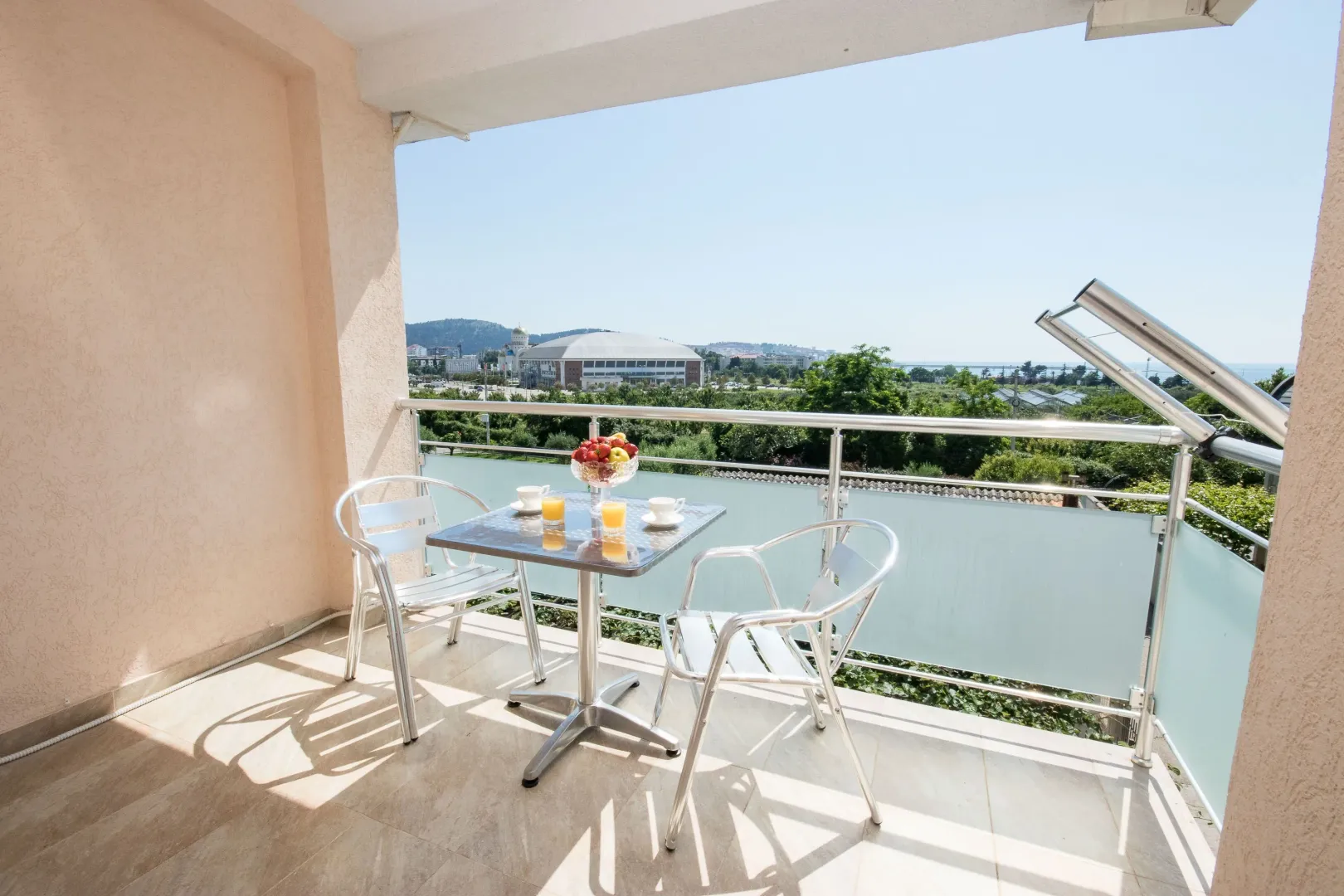 Furnished balcony with a table, chairs, and a view of the surroundings.