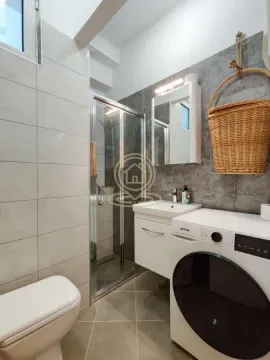Modernly equipped bathroom with a shower cabin, washbasin, and washing machine. - image 9