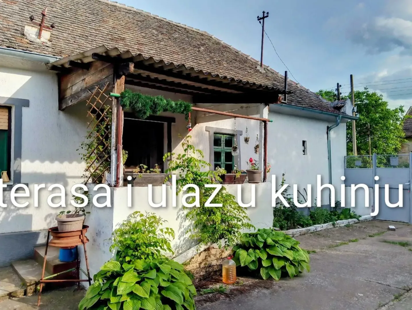 Spoljašnji izgled kuće sa natkrivenom terasom i ulazom.