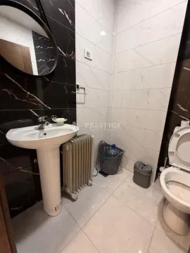 Small bathroom with a sink, toilet, and black and white tiles. - image 8