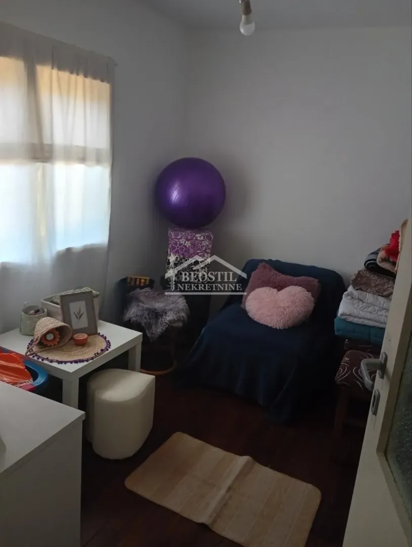 Small room with a bed, small table and various furniture.