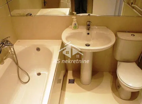Bathroom equipped with a bathtub, washbasin, and toilet. - image 19