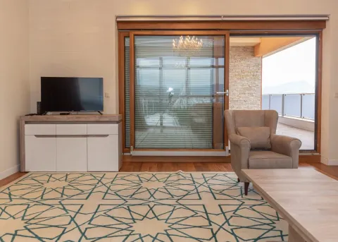 Living room with an armchair, TV cabinet, and access to the terrace. - image 2