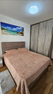 Namještena spavaća soba sa bračnim krevetom, ormarom i slikom na zidu. - image 6