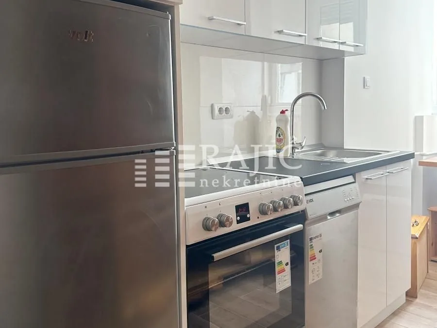Modern white kitchen with a refrigerator and built-in appliances.