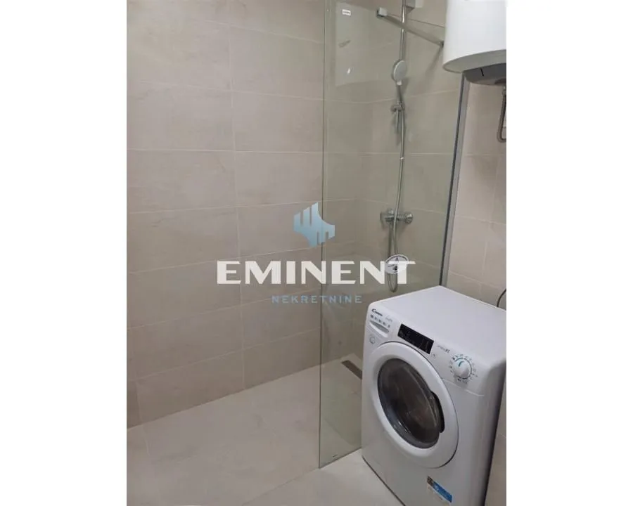 Bathroom with a walk-in shower and washing machine.