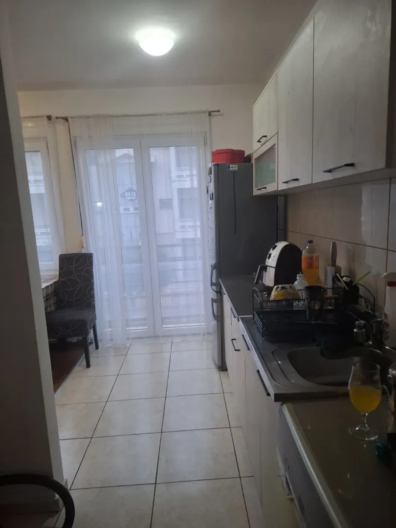 Funkcionalna kuhinja sa trpezarijskim dijelom i izlazom na balkon.