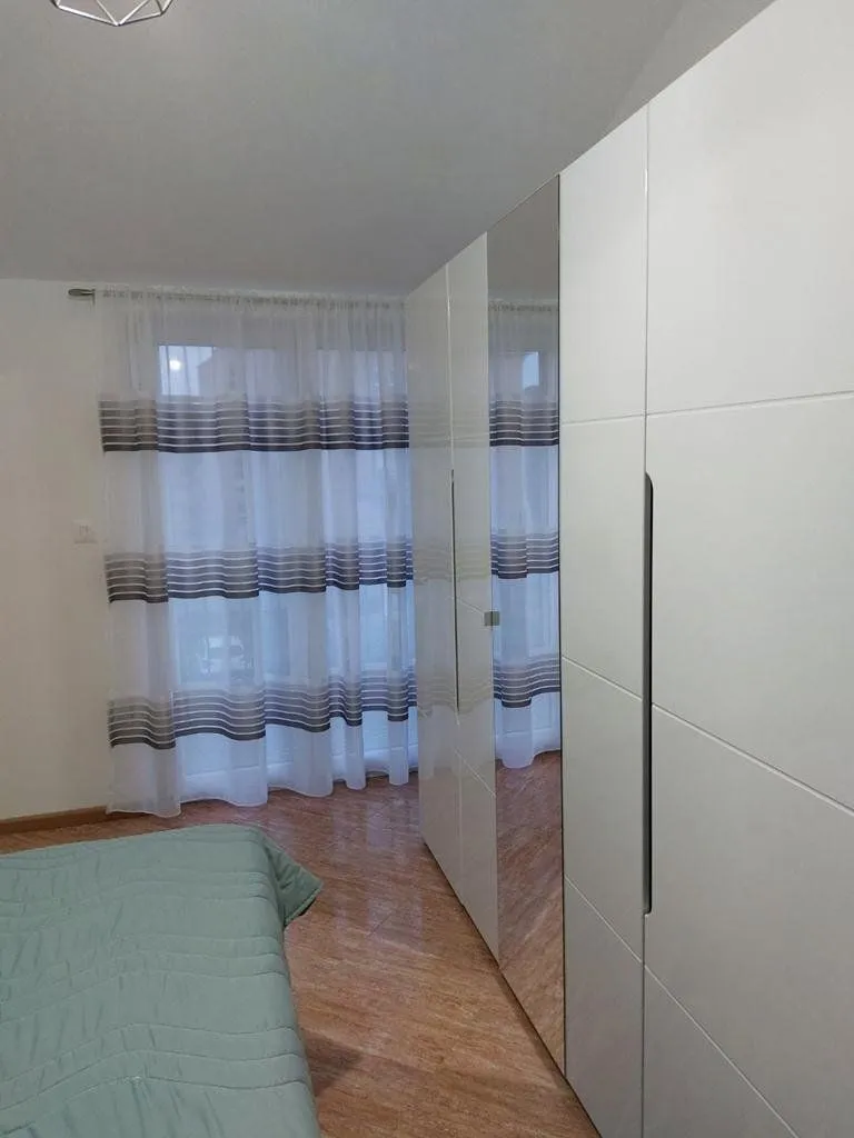 Bedroom with a large built-in wardrobe and a window.