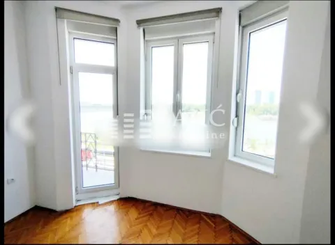 Empty room with hardwood floors and large windows. - image 4