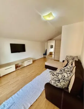 Living room with a corner sofa, television, and media console. - image 6