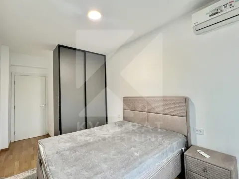 Furnished bedroom with a double bed, wardrobe, and air conditioning. - image 10