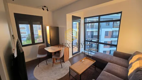Modern living room with a sofa, dining table, and large windows. - image 7