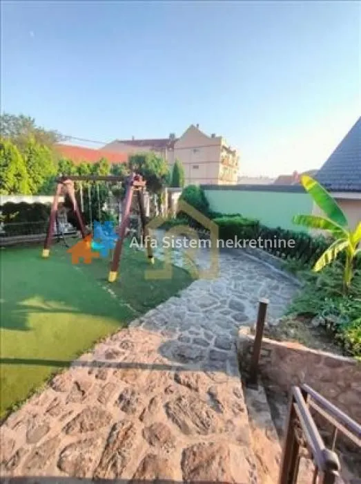 Landscaped courtyard with a stone path and children's playground.