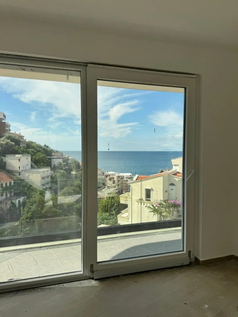 Sea view through a large window opening in the room.