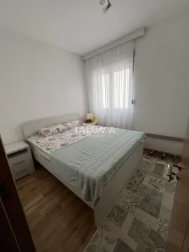 Spavaća soba sa bračnim krevetom, noćnim stočićem i prozorom sa zavjesama. - image 5