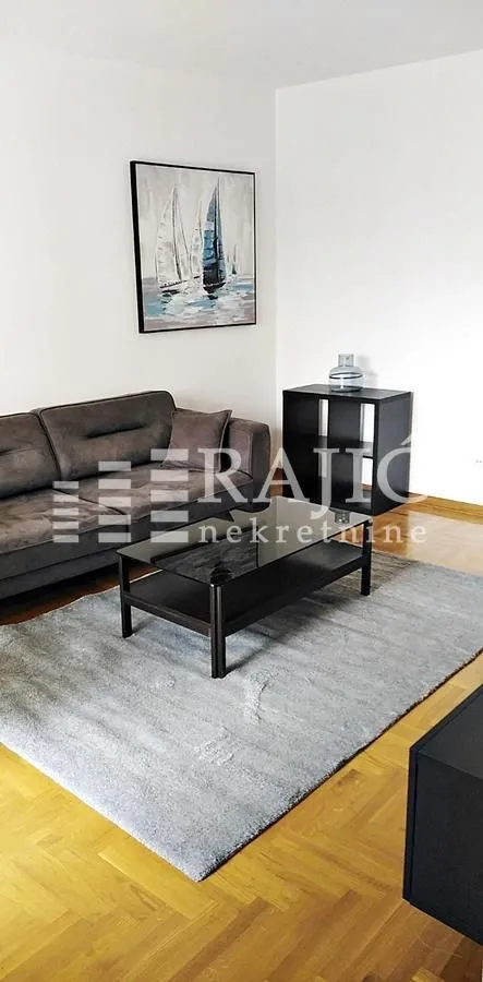 Living room with a sofa, coffee table, and rug.