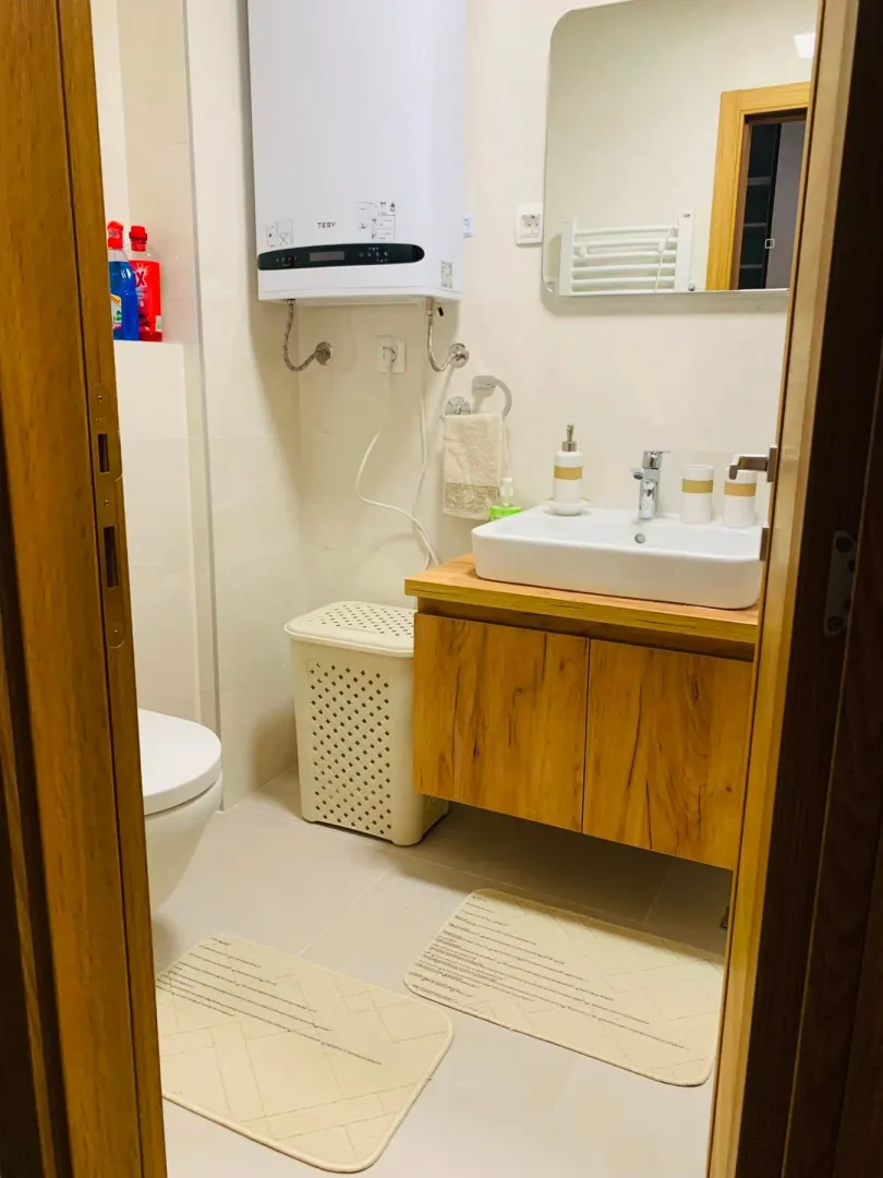A neatly arranged bathroom with a washbasin, toilet, and water heater.