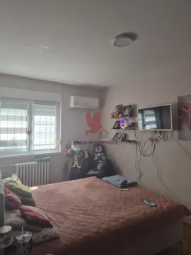 Furnished bedroom with a double bed, air conditioning, and a wall-mounted TV. - image 5