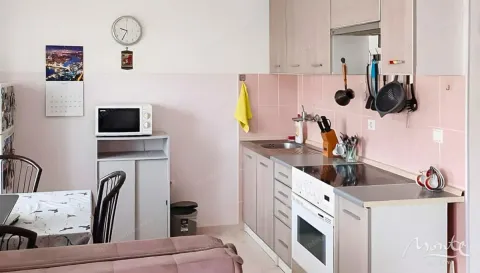 Kuhinja opremljena sa elementima, šporetom i trpezarijskim stolom. - image 21