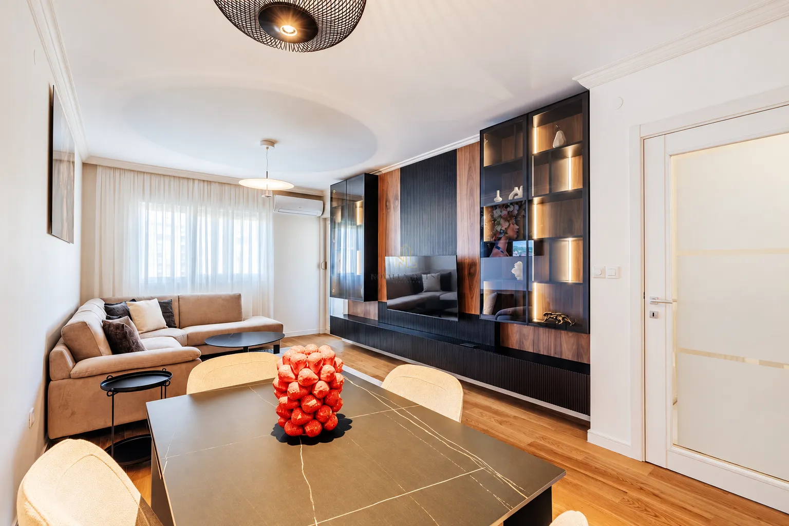 Living room with a sofa, dining table, and modern built-in cabinetry.