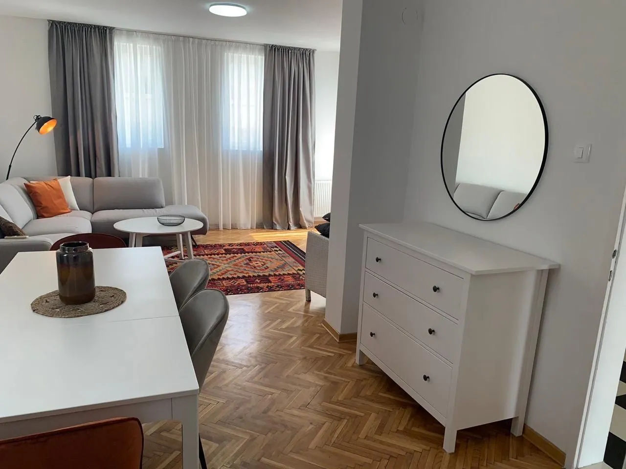 Bright and modernly decorated living room with a dining table.