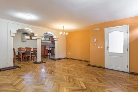 Spacious empty room with parquet flooring and decorative arches leading to a dining area. - image 23