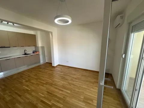 Living room with kitchen and wooden flooring. - image 3