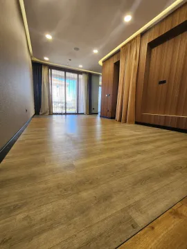 Empty room with wooden flooring, dropped ceiling, and a large window. - image 2