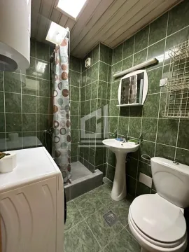 Kupatilo sa zelenim pločicama, umivaonikom, WC šoljom i tuš kabinom. - image 4