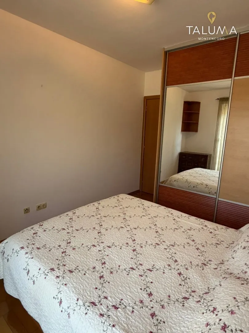 Bedroom with a double bed and a built-in wardrobe with a mirror.