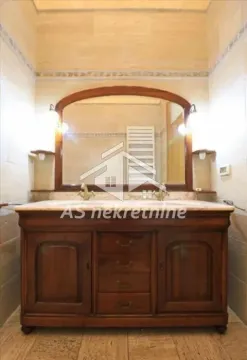 Bathroom with a wooden vanity and a large mirror. - image 22