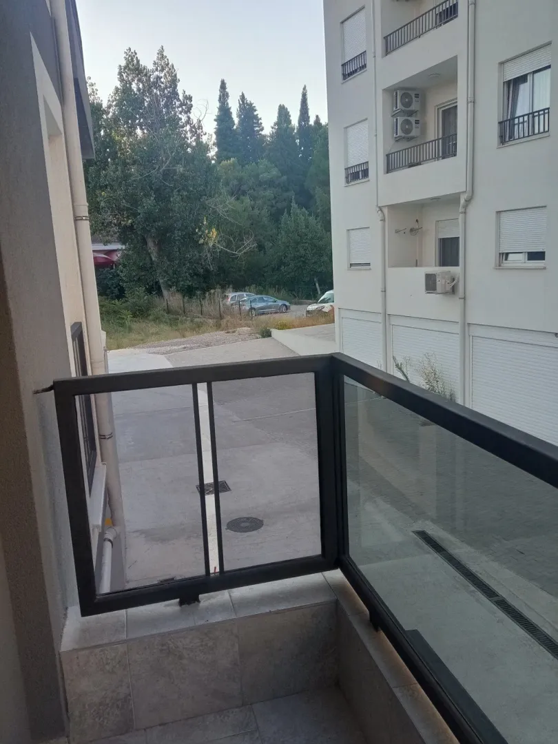 Pogled sa balkona na susjednu zgradu i okolinu.