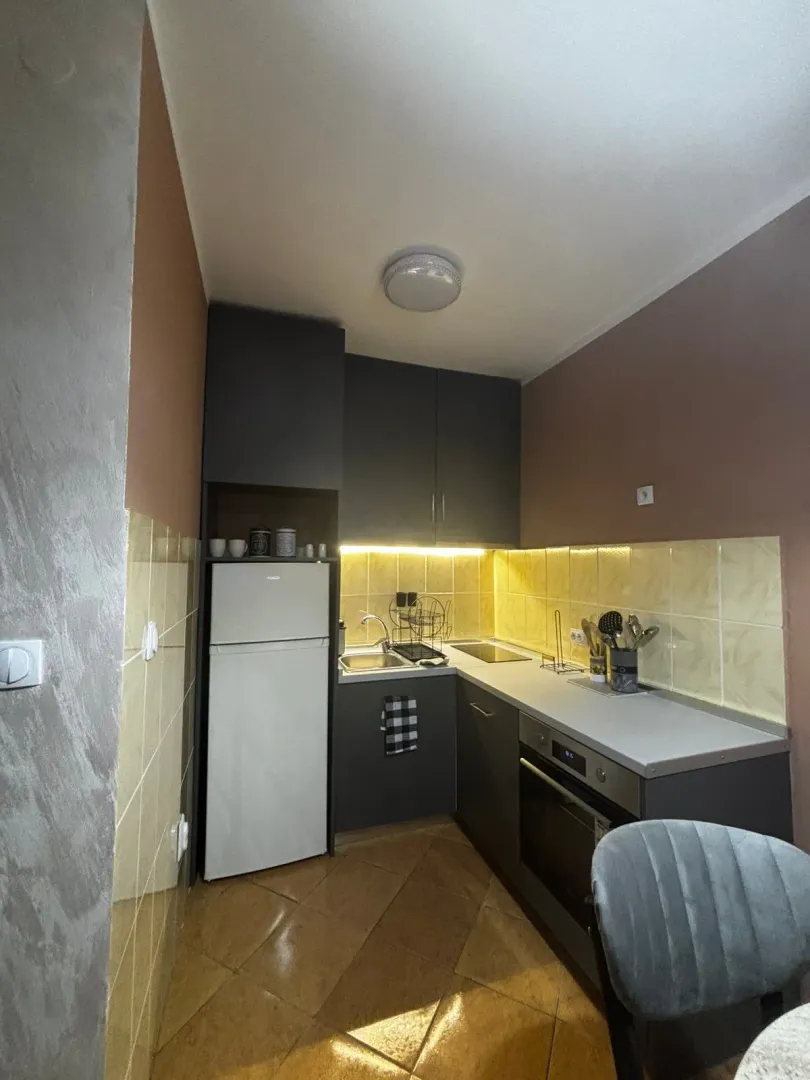 Small equipped kitchen with dark cabinets and a white refrigerator.