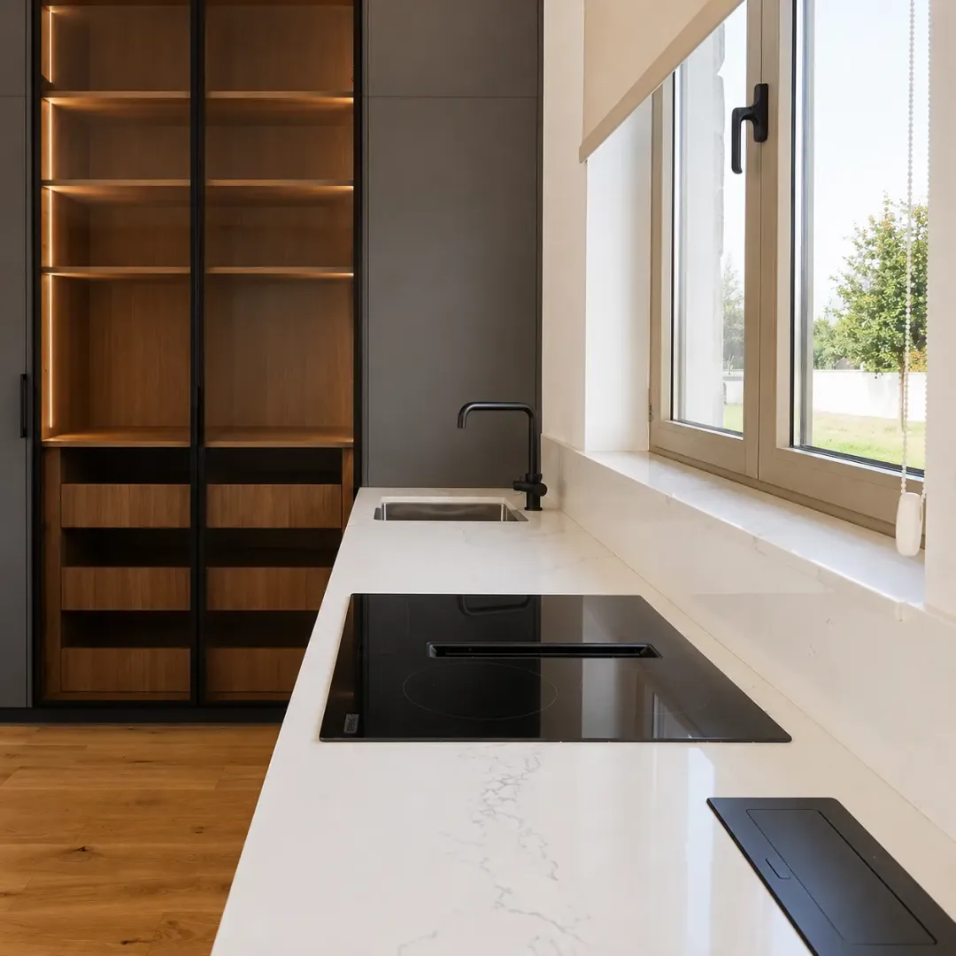 Modern kitchen featuring a built-in cooktop, sink, and a large wooden cabinet.