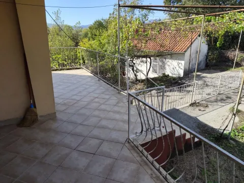 Popločana terasa sa ogradom i pogledom na dvorište i okolno zelenilo. - image 6