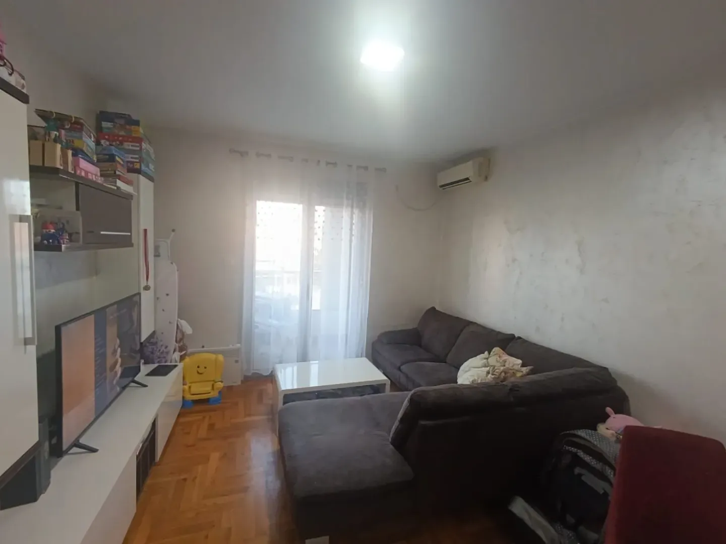 Living room with a corner sofa and a TV.