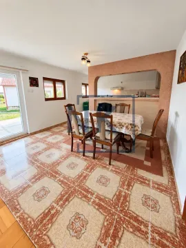 Dining area with a table, chairs, and a pass-through to the kitchen. - image 9