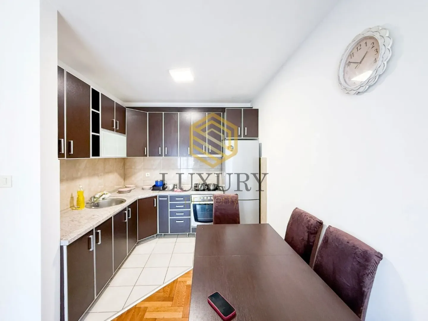 Kitchen with dark cabinetry and a dining table.