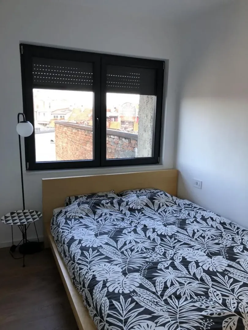Small bedroom with a double bed and a window overlooking the city.
