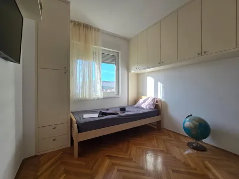 Small bedroom with a single bed, built-in wardrobes, and parquet flooring. - image 8