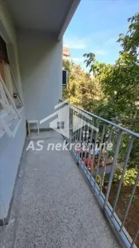 Long balcony with a metal railing and a view of greenery. - image 11