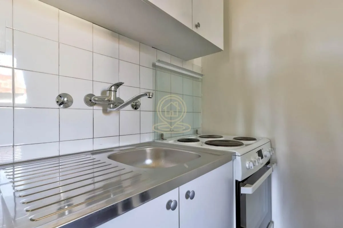 Small kitchen with a sink, cabinetry, and an electric stove.