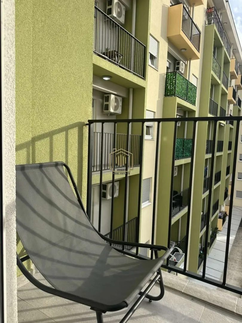 View from the balcony with a lounge chair towards the neighboring building.