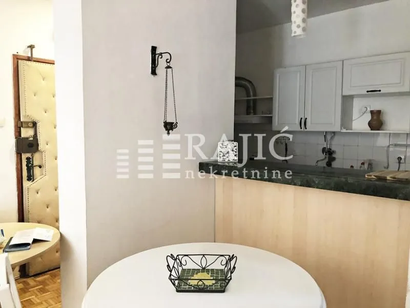 Smaller kitchen with a breakfast bar and dining table.