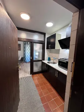 Small kitchen with dark cabinets and tiled flooring. - image 2