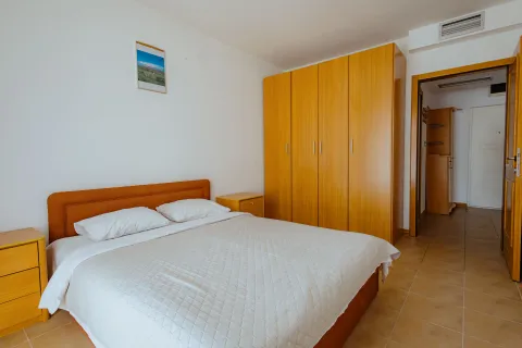 Bedroom with a double bed, wooden wardrobe, and nightstands. - image 13