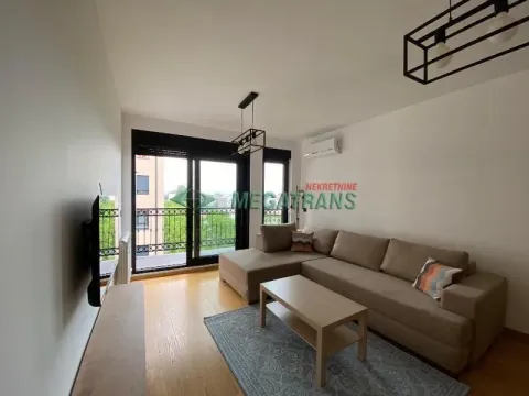 Living room with a sectional sofa, coffee table, and balcony access. - image 3