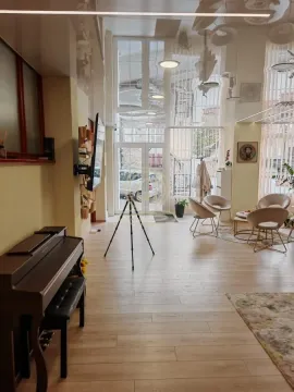 Spacious living room with seating area, piano, and high ceiling. - image 5