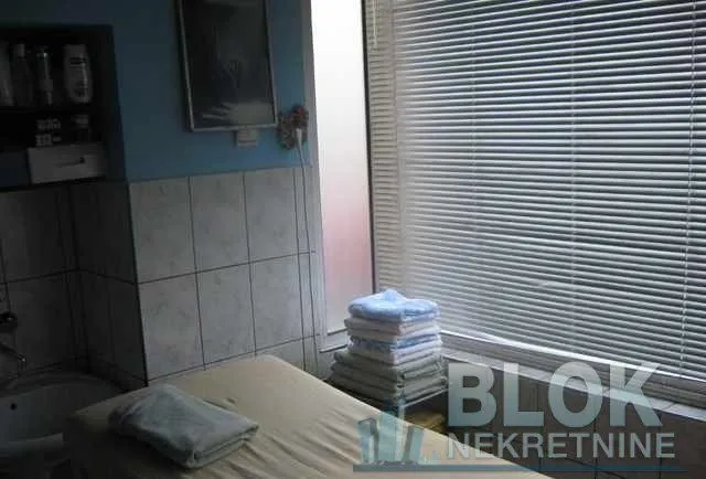 Bathroom with a window, sink, and stacked towels.